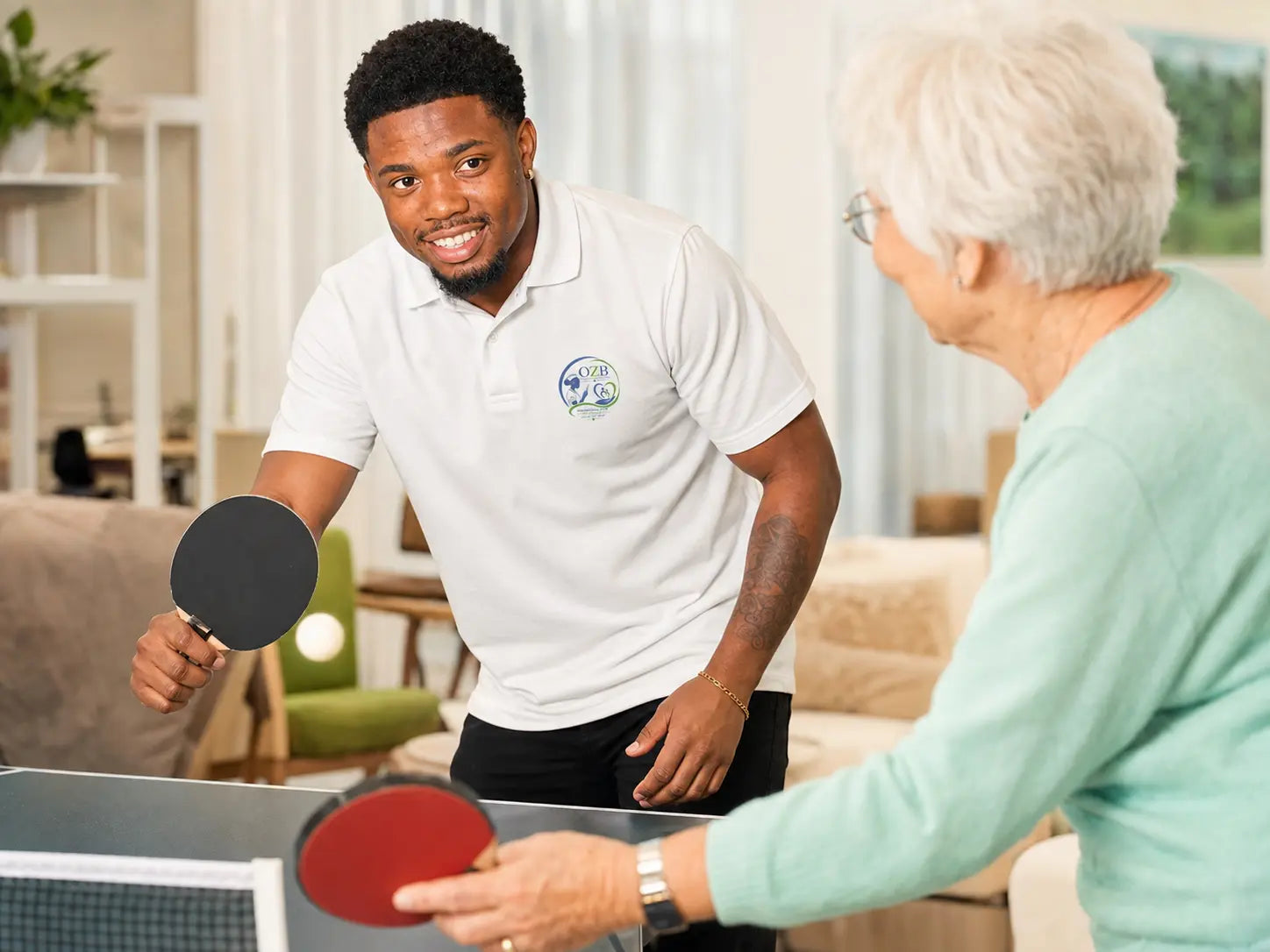 Jahfaari Zunder speelt tafeltennis met een oudere vrouw; sfeerbeeld ter illustratie